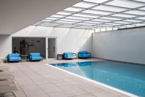 a pool with blue chairs and a swimming pool at Sesimbra Ocean Terrace in Sesimbra