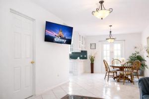 a living room with a table and a tv on the wall at Casa Real in Manuel F. Martínez