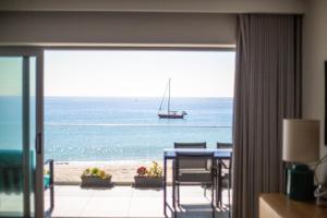 a room with a view of the ocean and a sail boat at Sesimbra Ocean Terrace in Sesimbra