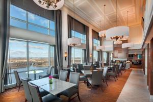 a restaurant with tables and chairs and large windows at Hilton Lac-Leamy in Gatineau