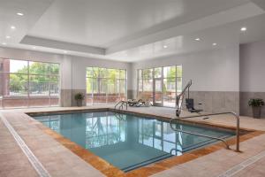a large swimming pool in a large room with windows at Embassy Suites Charlotte/Ayrsley in Charlotte