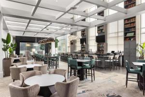 a restaurant with tables and chairs and a bar at Embassy Suites Charlotte/Ayrsley in Charlotte
