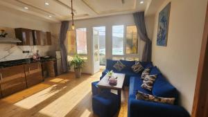 a living room with a blue couch and a kitchen at Padova Surf Hous in Imsouane