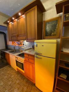 a kitchen with a yellow refrigerator and wooden cabinets at Vojko Holidays - Rustika in Koper