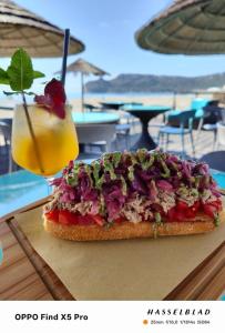 a sandwich and a drink on a table at Windofsand Room in Cagliari