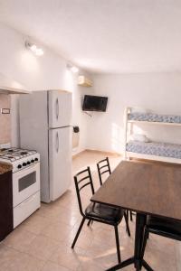a kitchen with a table and a white refrigerator at Gotas de Rocio N1 in San Antonio Oeste