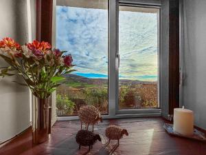 a room with a vase of flowers and a window at Hyfrydle Cottage in Talysarn