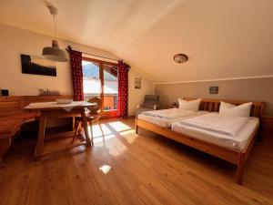 a bedroom with a bed and a desk and a table at Landhaus Waldhauser in Schönau am Königssee