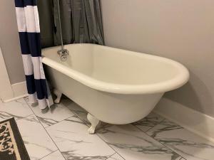 a white bath tub sitting in a bathroom at Classic California Bungalow Downtown in Bakersfield +24 photos