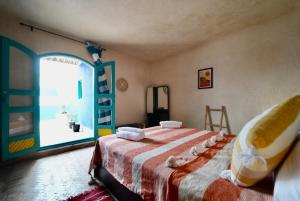 a bedroom with a bed and a large window at Riad Medina Charme et Sérénité in Essaouira