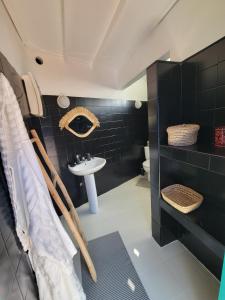 a black bathroom with a sink and a toilet at Riad Medina Charme et Sérénité in Essaouira +31 photos