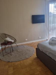 a bedroom with a bed and a chair and a rug at TM My Home in Novara