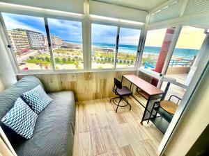 a room with a bed and a desk and windows at Costa de Caparica in Costa da Caparica