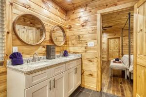 a bathroom with two sinks and a mirror at Leconte Mountain Lodge in Sevierville +93 photos