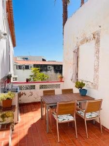 a patio with a wooden table and chairs on a balcony at Faro Town House in Faro