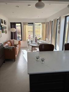 a living room with a couch and a table at Design Villa with Panoramic Views & Large Windows in Miðvágur