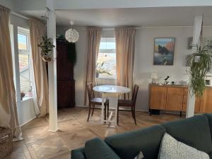 a living room with a couch and a table at Design Villa with Panoramic Views & Large Windows in Miðvágur