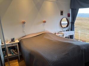 a bedroom with a bed and a mirror at Design Villa with Panoramic Views & Large Windows in Miðvágur +19 photos