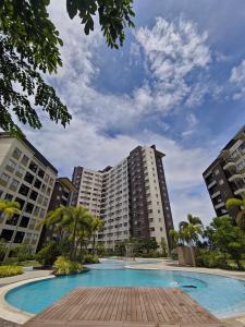 a large apartment complex with a swimming pool and palm trees at Tahanan in Iloilo City