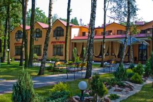 un gran edificio amarillo con árboles delante de él en Hotel Complex Zelenyi Gai, en Kopachuvka