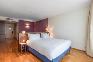 a bedroom with a large white bed with two pillows at DoubleTree by Hilton Hotel Cluj - City Plaza in Cluj-Napoca +35 photos
