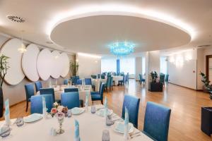 a conference room with tables and chairs and a chandelier at DoubleTree by Hilton Hotel Cluj - City Plaza in Cluj-Napoca