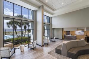a living room with a couch and chairs at The Island House Hotel a Doubletree by Hilton in Orange Beach