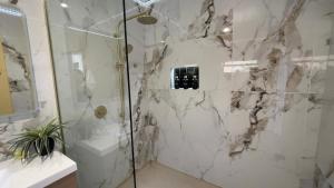 a bathroom with a shower with a glass door at Mels Retreat in Te Kuiti +54 photos