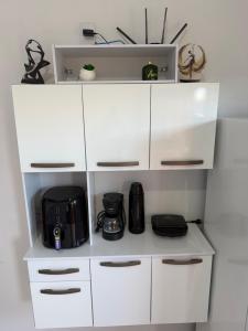 a white cabinet with a coffee maker and a microwave at VivaVida boungavilli 01 in Sinop