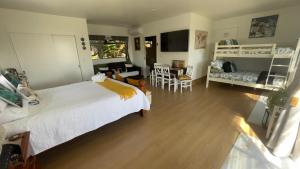 a bedroom with a large bed and a living room at Mels Retreat in Te Kuiti