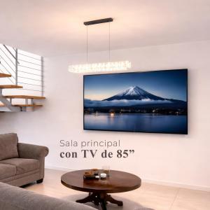 a tv hanging on a wall in a living room at Casa Nobleza in Manuel F. Martínez