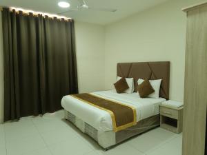 a bedroom with a large bed with black curtains at قولد شير 2 in Salalah +6 photos