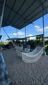 a hammock on a house with chairs and a view at Villas Lux Arenal in Fortuna
