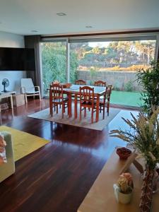 a living room with a table and chairs and a large window at Sunny Ofir in Fão
