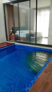 a large blue swimming pool in a room with a bedroom at Vincaza villa in Tlekung +7 photos