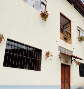 a white building with potted plants and a door at Big Vacation Hostel in Cusco +29 photos