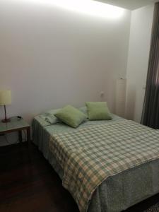 a bedroom with a bed with two green pillows at Sunny Ofir in Fão +43 photos