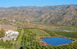 an aerial view of a vineyard with a house and a lake at El Pajar in Málaga