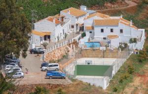 a group of houses with cars parked in a parking lot at El Pajar in Málaga