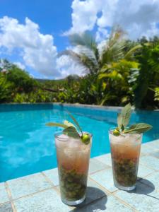 two cocktails on a table next to a swimming pool at Camisão CasaJuMa Pixixi in Aquidauana +17 photos