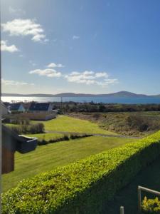 a view from the balcony of a house with a hedge at Ardnacassa in Kilcrohane +4 photos