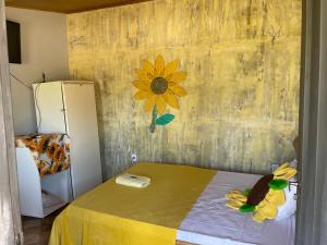 ein Zimmer mit einem Bett und einer Blume an der Wand in der Unterkunft Pousada MAKS in Ribeirão Preto