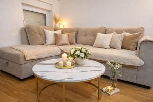 ein Wohnzimmer mit einer Couch und einem Tisch mit Kerzen in der Unterkunft Apartment Ivana Imotski near Makarska in Imotski
