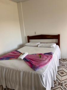 a bed with two blankets on top of it at Suítes FM in Cavalcante