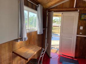 ein Zimmer mit einer Bank, einem Fenster und einer Tür in der Unterkunft Pousada MAKS in Ribeirão Preto