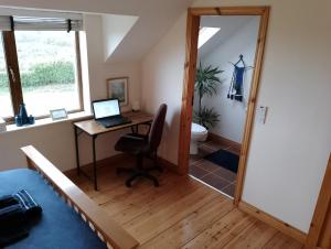 a room with a desk and a laptop on a table at Ardnacassa in Kilcrohane