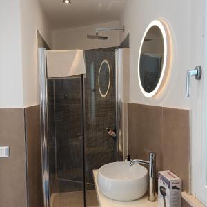 a bathroom with a sink and a shower with a mirror at The Garden Suites in Viterbo