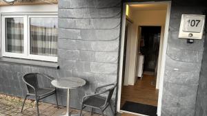 a table and two chairs sitting next to a building at Ferienwohnung Safran 2 in Konz