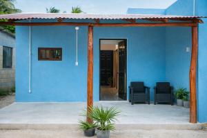 a blue house with two chairs on a patio at Paradise Renewed Beach House for Deep Relaxation in El Cuyo +23 photos