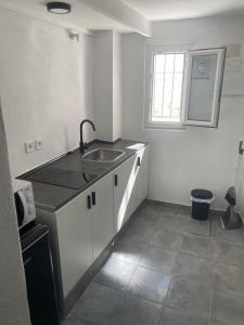 a white kitchen with a sink and a window at Moreria Suites in Constantina +40 photos